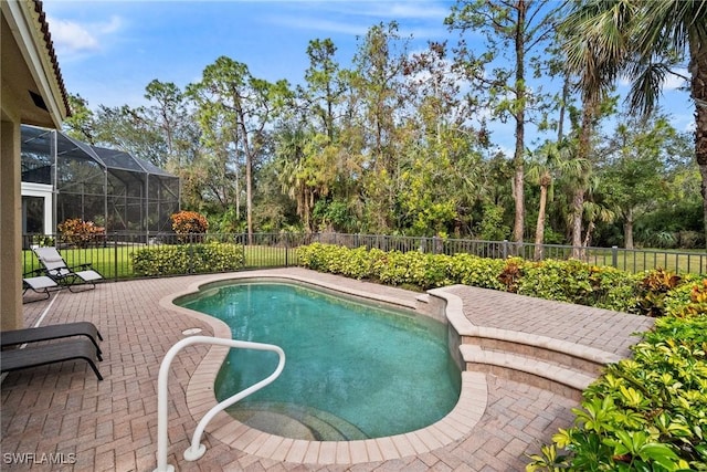 view of swimming pool with glass enclosure and a patio