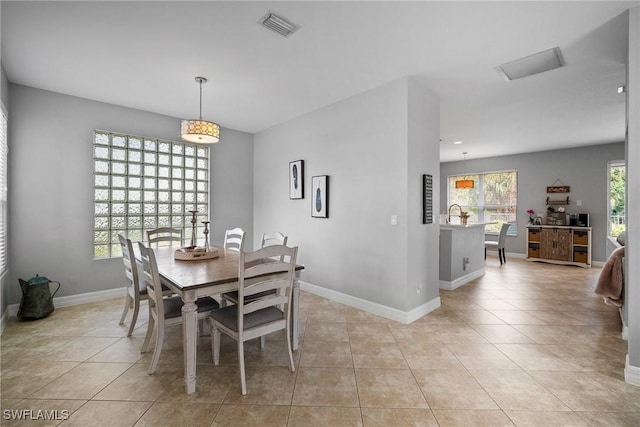 tiled dining room featuring a healthy amount of sunlight