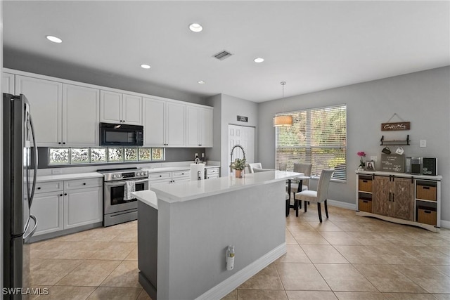 kitchen featuring white cabinets, decorative light fixtures, stainless steel appliances, and light tile patterned flooring