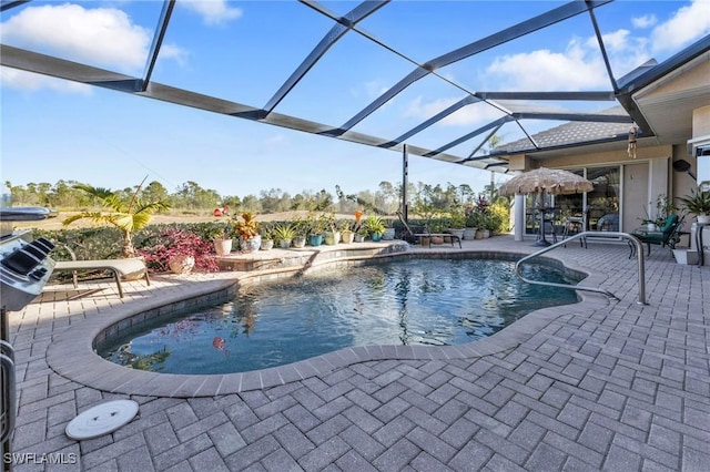 view of swimming pool featuring glass enclosure and a patio