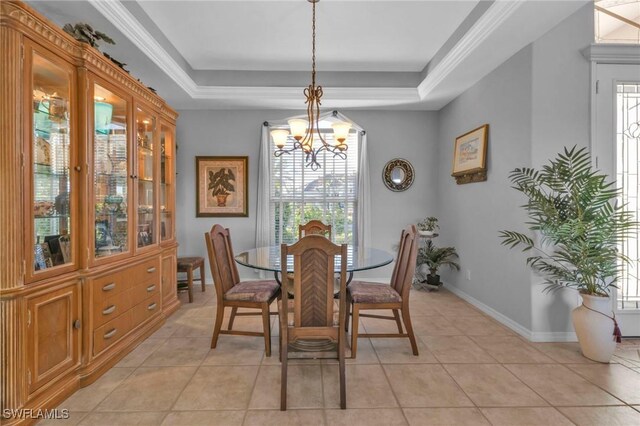 tiled dining room featuring a tray ceiling, a chandelier, and ornamental molding