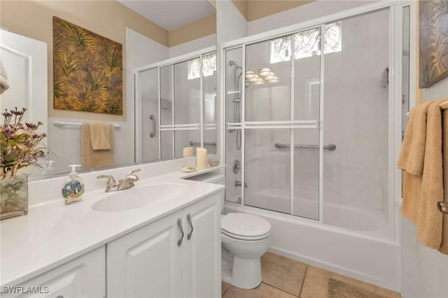 full bathroom with combined bath / shower with glass door, vanity, tile patterned floors, and toilet