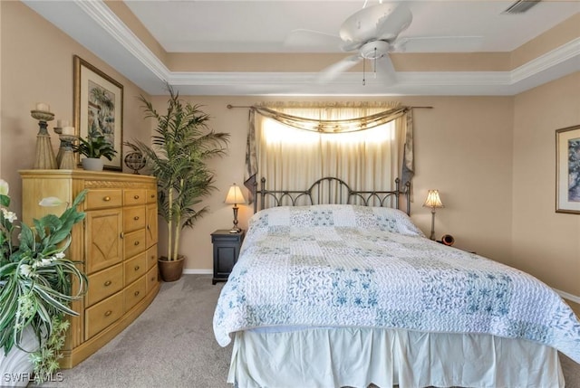 carpeted bedroom featuring a tray ceiling and ceiling fan