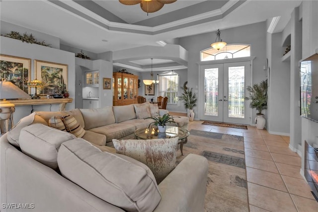 living room featuring french doors, a raised ceiling, crown molding, ceiling fan, and light tile patterned flooring