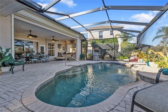 view of pool featuring glass enclosure, ceiling fan, and a patio