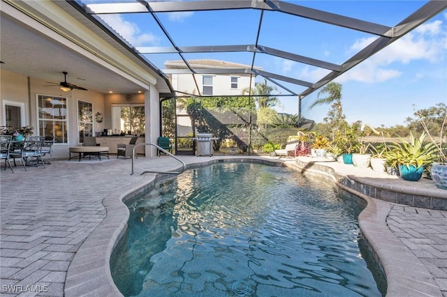 view of swimming pool featuring outdoor lounge area, ceiling fan, a patio, and glass enclosure