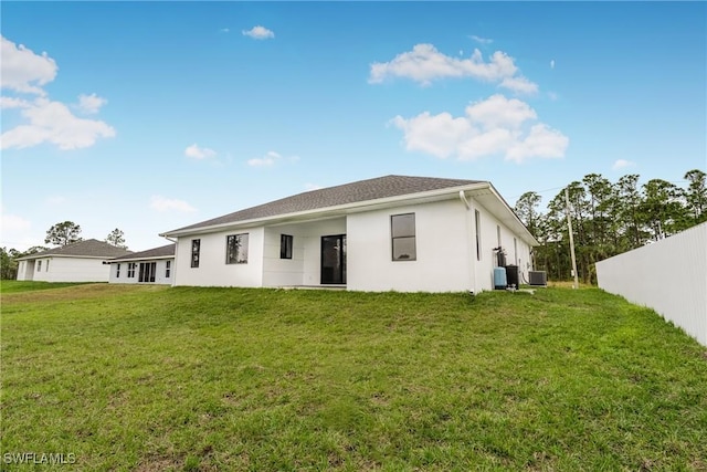 back of house featuring a lawn and central air condition unit