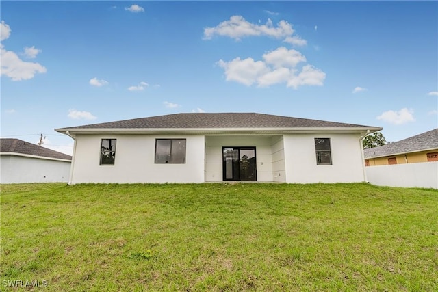 rear view of property featuring a yard