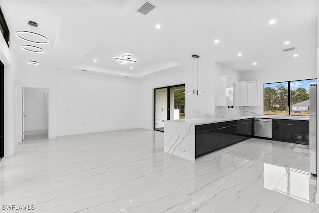 kitchen with hanging light fixtures, stainless steel appliances, a raised ceiling, kitchen peninsula, and white cabinets