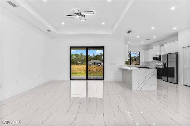 kitchen with a kitchen breakfast bar, decorative light fixtures, light stone counters, white cabinetry, and stainless steel appliances