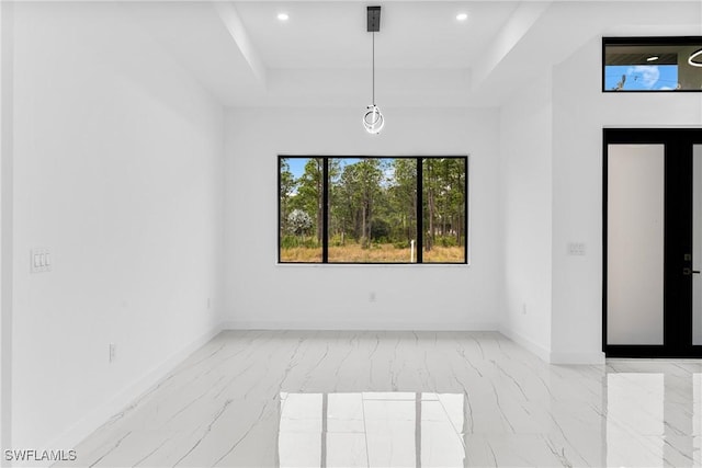 unfurnished room with french doors and a raised ceiling