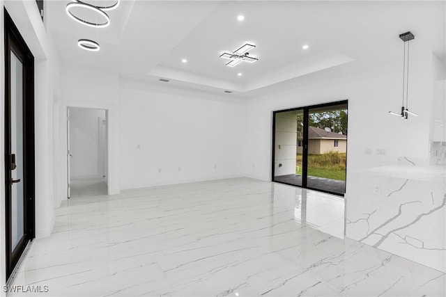 unfurnished room featuring a raised ceiling