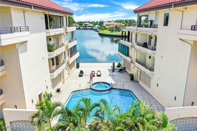 view of pool featuring a water view and a patio area