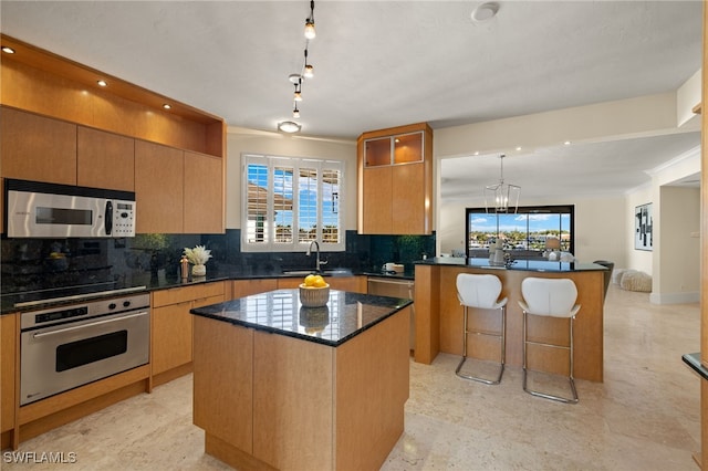 kitchen with sink, appliances with stainless steel finishes, plenty of natural light, and a kitchen island