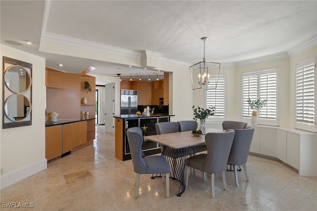 dining area featuring a notable chandelier, baseboards, and crown molding