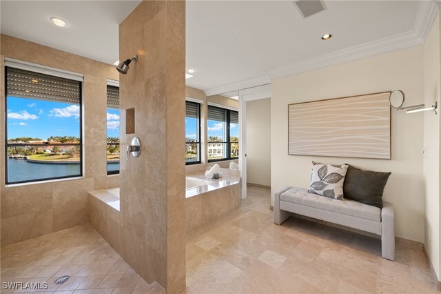 bathroom with crown molding, tiled shower, and a water view