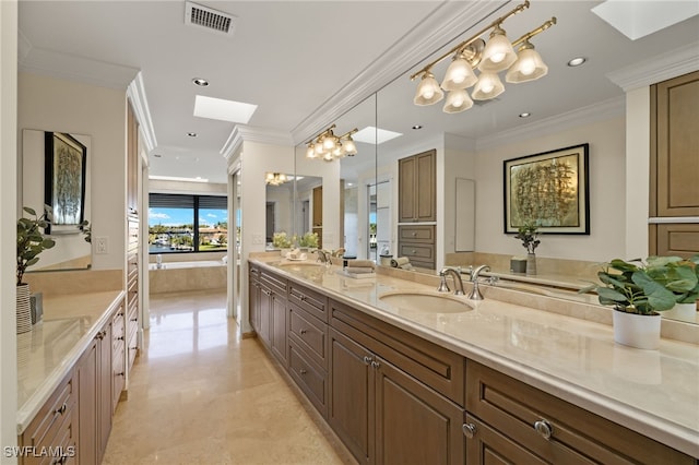 bathroom featuring crown molding, a skylight, visible vents, and a sink