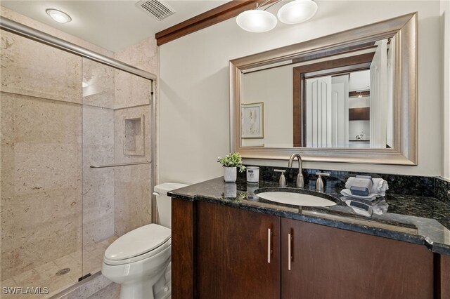 bathroom with toilet, walk in shower, and vanity