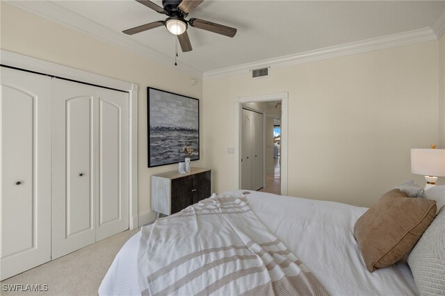 carpeted bedroom with a closet, ceiling fan, and crown molding