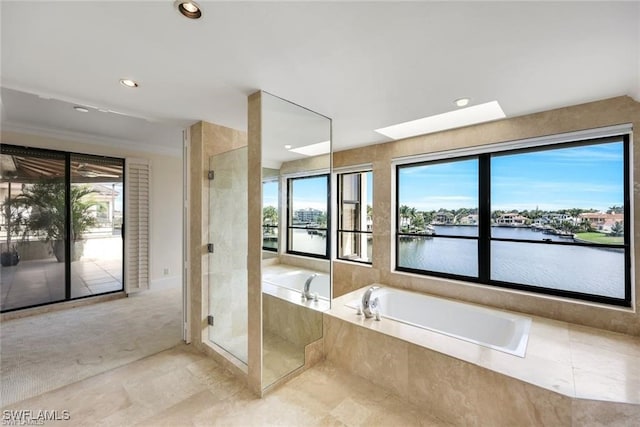 bathroom with a skylight, a water view, and plus walk in shower