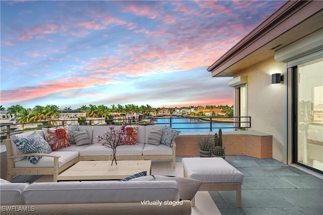 patio terrace at dusk with a balcony and an outdoor hangout area