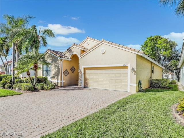 mediterranean / spanish-style home featuring a front yard and a garage