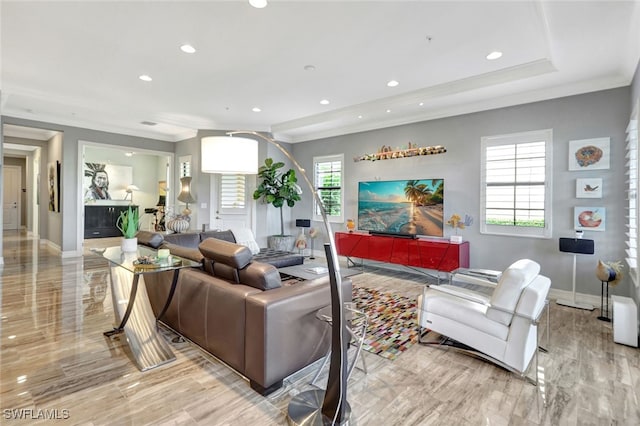 living room with a raised ceiling and ornamental molding