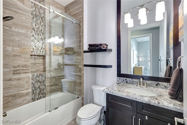 full bathroom with vanity, toilet, and combined bath / shower with glass door