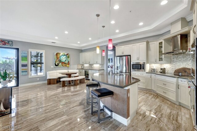 kitchen featuring decorative backsplash, appliances with stainless steel finishes, a breakfast bar, decorative light fixtures, and a kitchen island