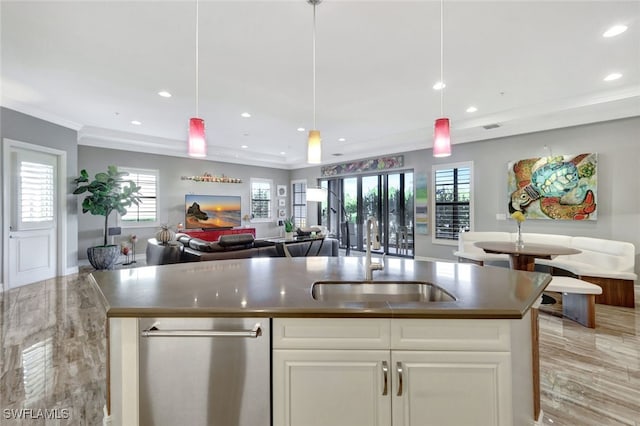 kitchen with crown molding, sink, pendant lighting, a center island with sink, and white cabinets