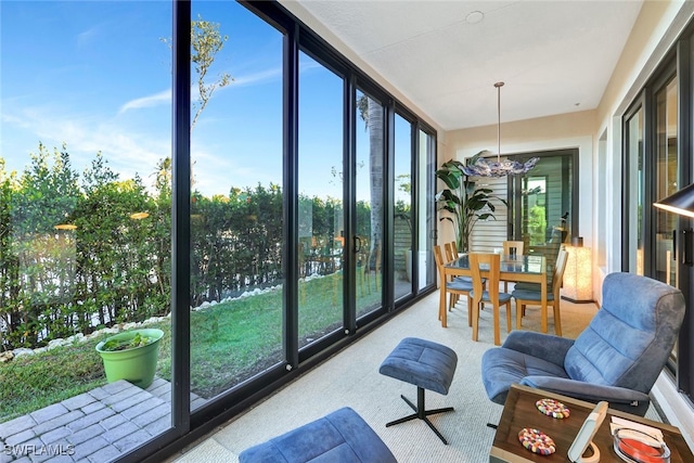 sunroom featuring a water view