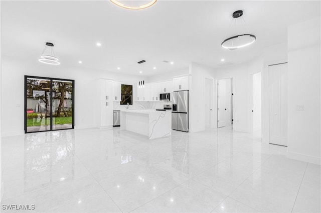 kitchen featuring stainless steel refrigerator with ice dispenser, pendant lighting, white cabinetry, light stone counters, and a kitchen island