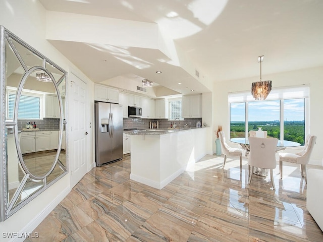 1065 Borghese Ln Unit 701, Naples, FL 34114 - kitchen featuring appliances with stainless steel finishes, white cabinetry, decorative backsplash, light countertops, and plenty of natural light