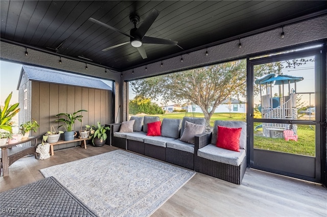 sunroom / solarium with ceiling fan, wood ceiling, a wealth of natural light, and track lighting