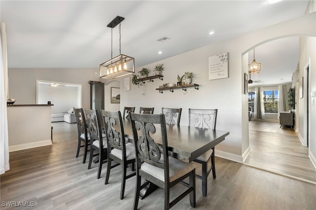 dining space featuring hardwood / wood-style flooring, ceiling fan, and vaulted ceiling