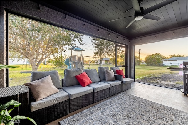 sunroom featuring ceiling fan and wooden ceiling