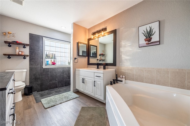 full bathroom with vanity, toilet, wood-type flooring, and shower with separate bathtub