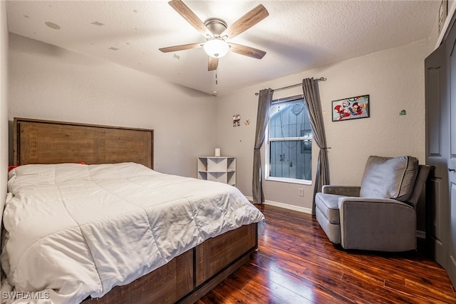 bedroom with a textured ceiling, ceiling fan, and dark wood-type flooring