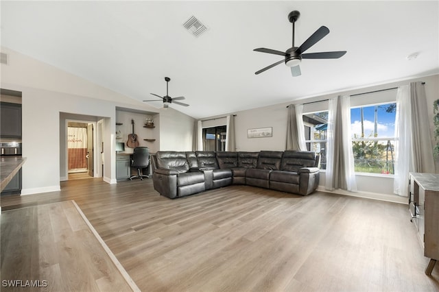 living room featuring light hardwood / wood-style floors, vaulted ceiling, and ceiling fan