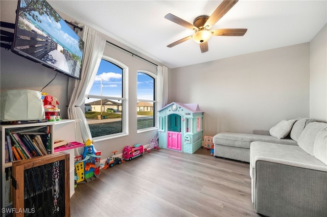 game room with light hardwood / wood-style floors and ceiling fan