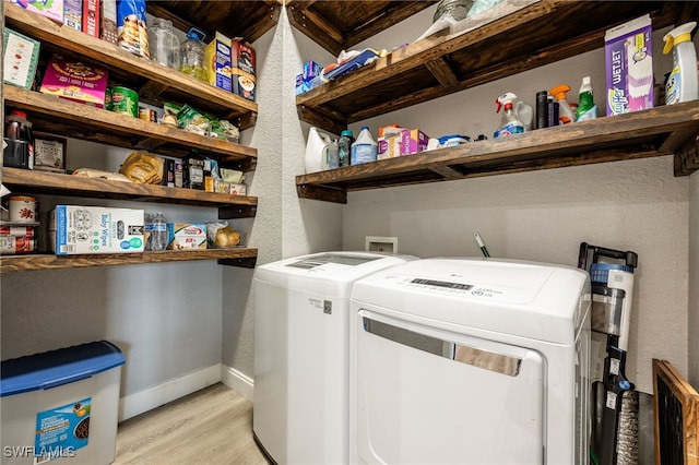 laundry area with light wood-type flooring and washing machine and dryer