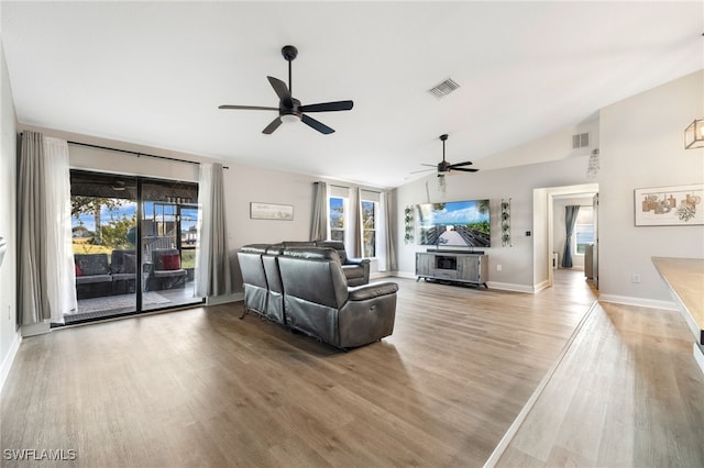 living room with ceiling fan, light hardwood / wood-style floors, and lofted ceiling