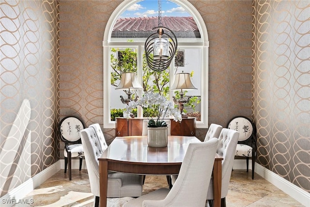 dining space with marble finish floor, baseboards, and wallpapered walls