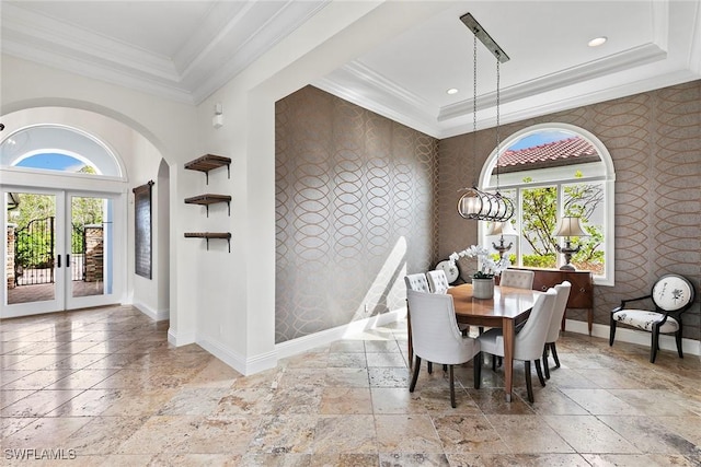 dining space featuring stone tile floors, crown molding, baseboards, a wealth of natural light, and wallpapered walls