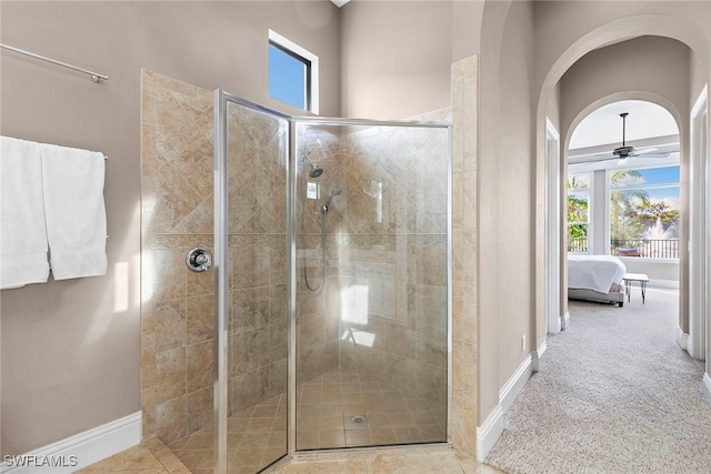 bathroom with a stall shower, ceiling fan, ensuite bath, and baseboards