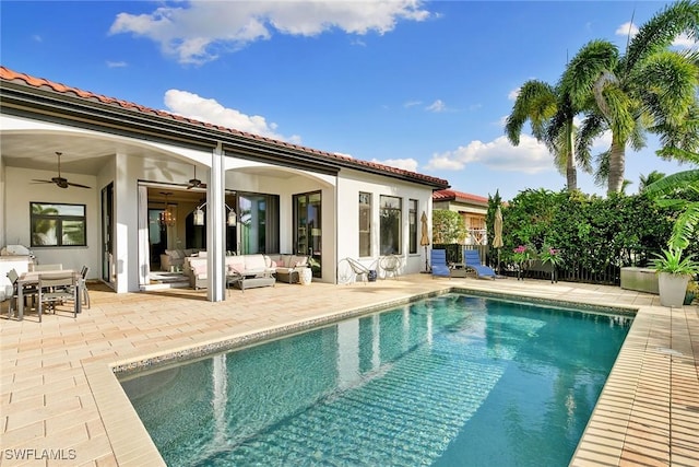 pool with an outdoor hangout area, a patio area, and a ceiling fan