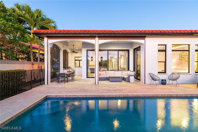 back of property featuring fence, an outdoor living space, a fenced in pool, stucco siding, and a patio area