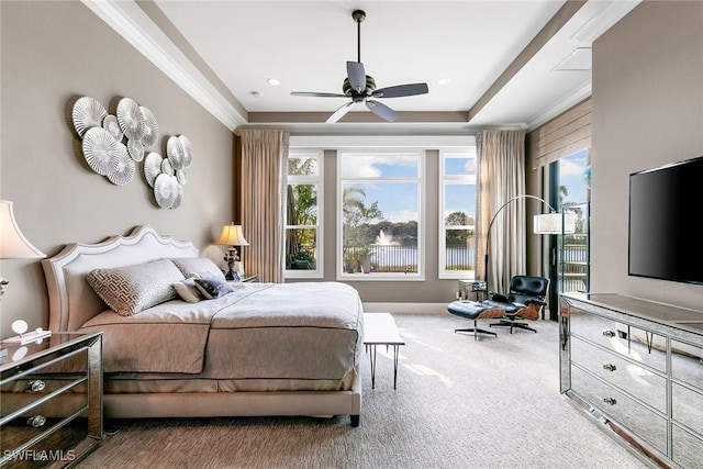 bedroom featuring carpet, multiple windows, a tray ceiling, and ornamental molding