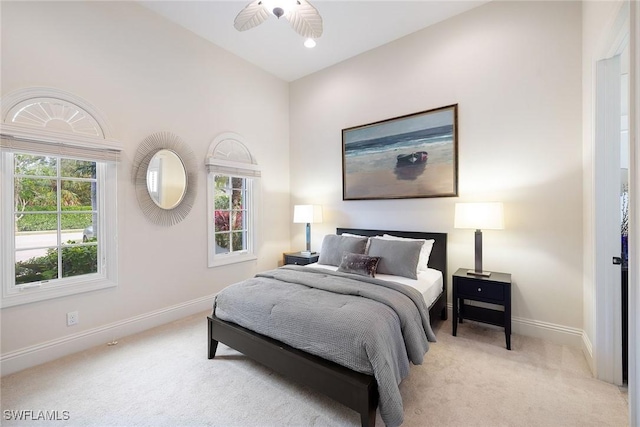 bedroom featuring high vaulted ceiling, light carpet, and baseboards