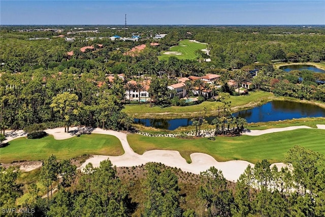 drone / aerial view with a water view, golf course view, and a wooded view